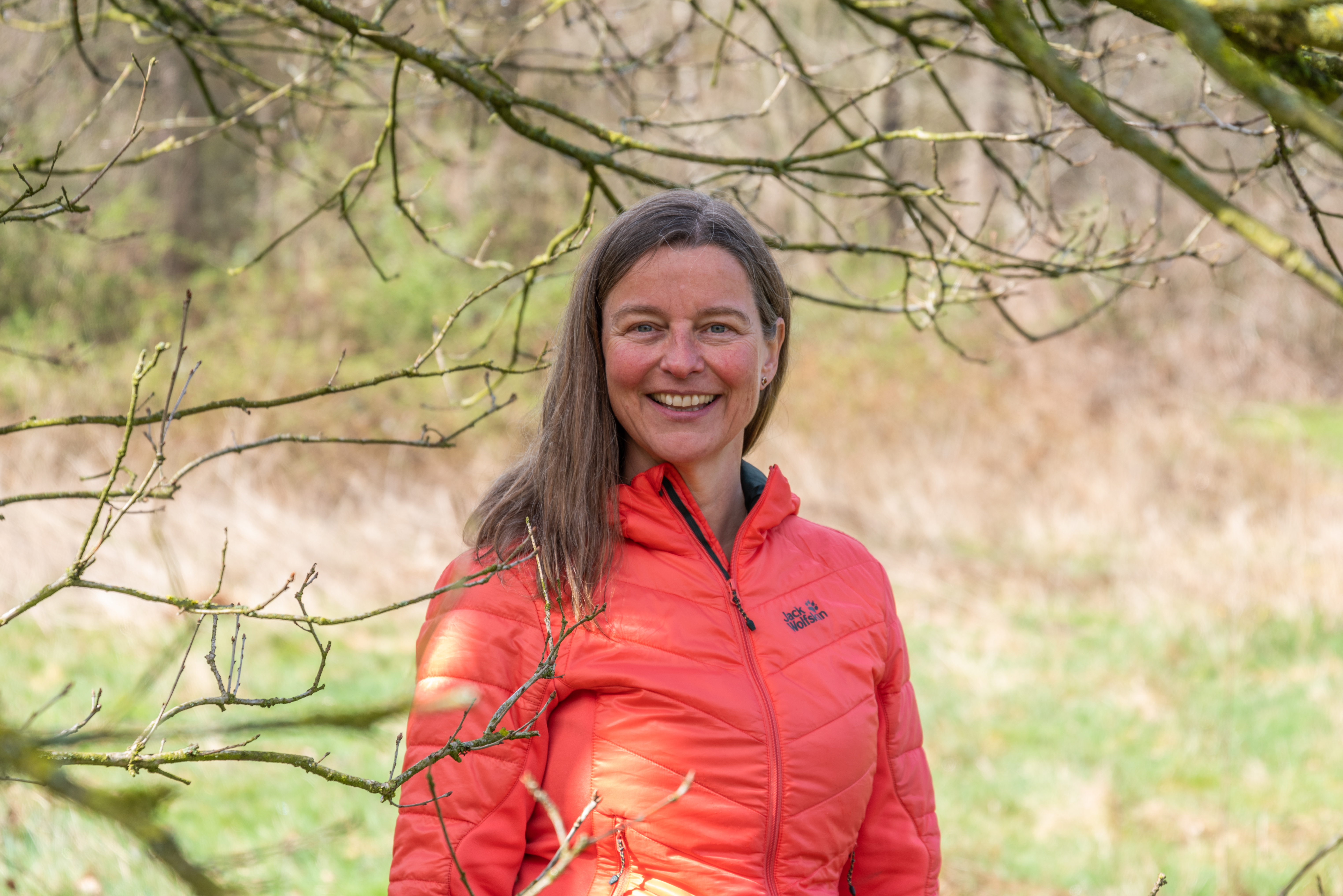 Coach Brigitte in de natuur. Vrolijk, in beweging en verbonden met haar omgeving